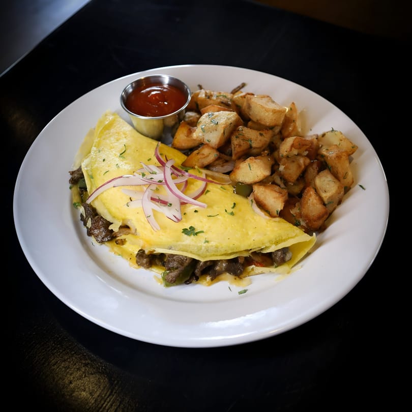 A V 14 Street Lounge omelet with steak, red onions, and a side of home fries and ketchup.